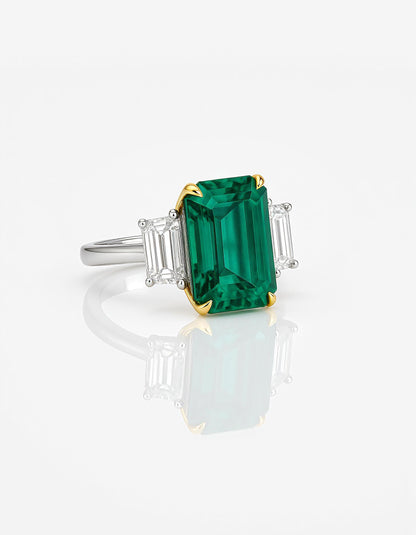&quot;Abigail&quot; White and yellow gold three-stone ring with an emerald-cut Green emerald center and trapezoid diamond side stones.