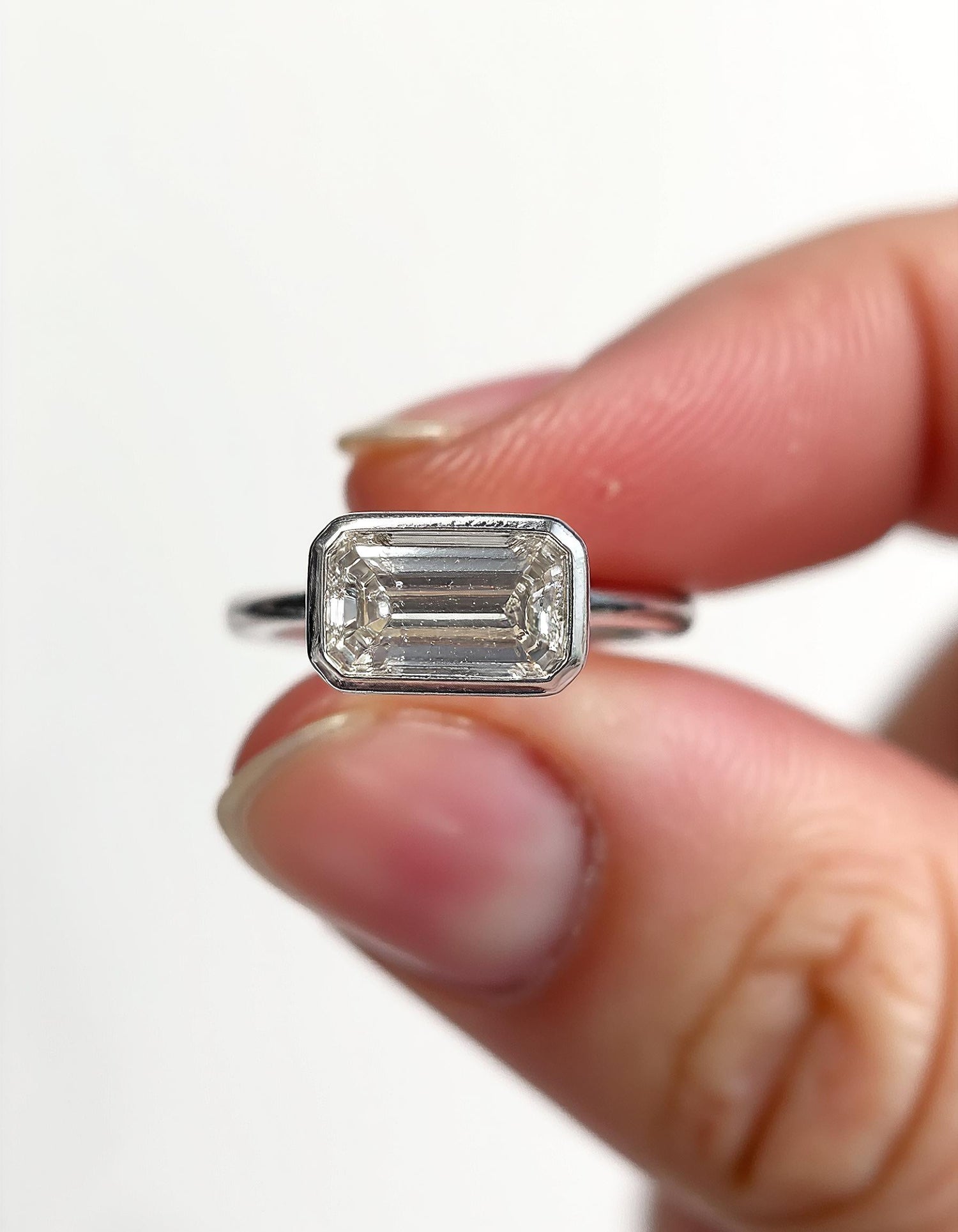 &quot;Lana&quot; Emerald Cut diamond solitaire in Bezel setting set Horizontally