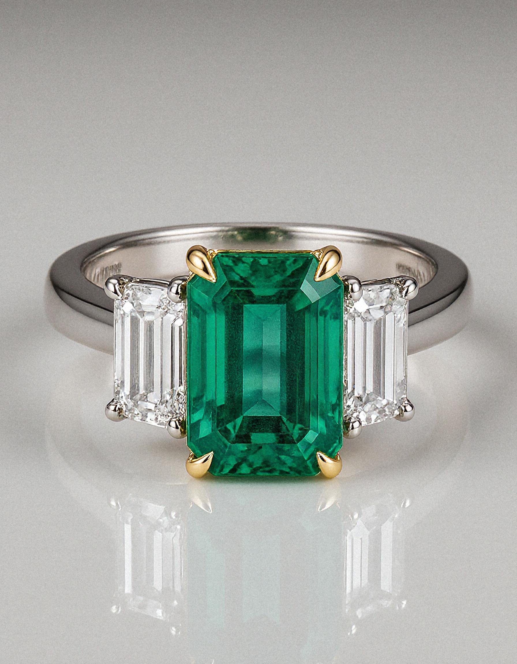 &quot;Abigail&quot; White and yellow gold three-stone ring with an emerald-cut Green emerald center and trapezoid diamond side stones.